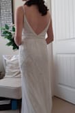 I love this dress! From the second I took my first peek through the garment bag zipper I couldn't wait to try it on. The quality of the bead work is excellent, the color is white, but not too white, and overall it feels well made. It fit well straight out of the box, and I'll just need to get it hemmed, and I'll get the straps reinforced and fit to size. It's a little bit heavy and the adjustable straps lengthened back out after a while wearing it. There aren't any cups in it, so I'll probably have something a little supportive added in as well, as I'm a  34 D and planning to dance! I can't wait for the big day! I feel great in this dress. - Er M.