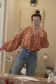 I was a little unsure of the top when I pulled it out of the packaging but I was very pleased with how it ended up looking on. The neckline is very flattering and the balloon sleeves give it a cute touch. The top is a little cropped but I've tried it on with a couple of different pairs of my high-waisted jeans and it comes down long enough to not really expose my stomach. When I raise my arms maybe a tad but nothing crazy. It's a very cute spring/summer blouse. - Kaitlyn M.