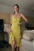 This dress is incredibly flattering from every angle. The ruffle & tie accents harmonize so well with the cut and shape of the garment itself. The lime color is a yellow-based green, so it really would suit both warm & cool skin tones fabulously. I can tell it's going to wrinkle easily, but nothing a little steam can't fix. I also feel like it could be a bit more snug around the midsection, as this is my usual size but I could definitely size down comfortably. Attached photo of the dress straight out of the bag. - Lindsey D.