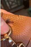 I bought this bag in October, 2020 and it started falling apart a little over a year later. The grommet where the strap attaches fell off and the material in another spot has a tear. The stitching is coming loose in another place.
I really liked this bag but it isn't durable for everyday use. I don't carry unusually heavy stuff in my bag - wallet, phone, keys, small makeup bag and that's it. No water bottle or tablet. Very disappointing because I liked the look of this bag. - Elise L.