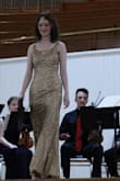 Wore this for a performance, was very happy with it. As other reviews have mentioned, it sheds glitter like absolute crazy and everyone in my dorm now hates me. Can't get it all off my bag or coat, but have adopted a stoic attitude. 
Note that it is made for a person much longer and a bit wider in the torso than I am, so I had to take in the straps quite a bit and add darts at the waist. It was also almost too tight in the hips, even though I'm not insanely curvy. Neither alteration was a big deal though, I don't expect tight dresses to be perfectly fitted out of the box, and the dress looked great afterwards. 
Very flattering, reasonably comfy, lots of sparkly wow factor. - Bernadette M.