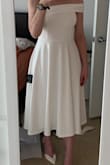 Definitely 50's vibes with a modern twist. This dress fits very well. The one shoulder is not too tight and not too lose. The fabric is heavier weight, a bit stretchy, and hangs nicely. I have wide hips for my frame (see measurements) which can make it challenging to find garments that fit properly, but this dress accommodated. The only bad things were the closures. The hook and eye closure at the top of the zipper came off very easily, so I will have to sew it back in. The zipper is also hard to pull up and down which ended up being kind of a good thing considering the hook and eye issue. I bought this as rehearsal dinner dress and a backup reception dress in case my wedding dress couldn't be bustled. - Natalie R.