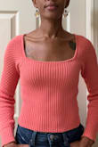 This sweater is such a warm vibrant salmon pink! The knit pattern on the sleeves and the tie on the back are so sweet! The hem hits right at the top of my belly button so I wear it with high-waisted pants. I wish they had a longer version! I bought it for cool days in the spring and summer - Stephanie S.