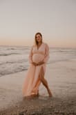 I loved this dress for my sunset beach maternity pictures! I bought my prepregnancy size because I figured the skirt would be flowy enough for my belly at 31 weeks! My bust had grown a couple of cup sizes and it still fit as well, the waist is elastic! It's very comfortable and can wear it when I'm not pregnant too! Highly recommend!!! - Adaline C.