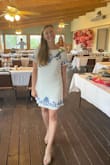 I wore this dress for my bridal shower and got soo many compliments on it! I was a little nervous wearing it because it does run a little short. If I had to raise my hands completely over my head it would expose my butt. Luckily, I made sure my arms didn't have to raise that high! It was a little tight around my shoulders but not so much that I would size up. I also was so bummed that every time I sat down it wrinkled, even after ironing it and steaming it but I still absolutely love this dress! - Kasey W.