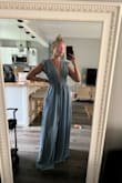 I am between a small and medium because I am smaller on top than on the bottom. Because of the flowy bottom, I decided to get a small and it fits perfectly! The length is long if I'm not in shoes but it will be perfect with 3-5" heels. The fabric is slick and the color is exactly the same as the photos. There is a slit right up the front center that I didn't notice in other photos. My sister thought it was a jumpsuit when I sent a photo! - Nicki K.