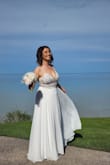 Such a simple, elegant and beautiful dress! I fell in love with this dress the moment I saw it! The fabric is very good quality and those beads are absolutely amazing. I was lucky to have perfect sunny weather on my wedding day and those beads were glowing the entire time. The dress runs a little bit small, or maybe it's just my body shape, but I had to get a size 6 when normally I wear size 2 on all dresses. The dress needed tailoring since I am petite and I had to cut almost 5" from the length of it. Based on another review for this dress I ended up adding a white fabric underneath the part where it is transparent. The opening in the back was a bit loose, but I taped it to my skin using double-sided fabric tape and it looked perfect. I would recommend this dress to anyone. It's almost wrinkle-free, so light and comfortable. - Liliana I.