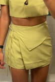 The material has no give, so aside from carefully pulling the skort up over my hips, they fit perfectly. I could go the next size up but I think the next size up might not fit as well. It holds in my stomach. These are definitely standing-up skorts, if I were to sit, the leg holes feel like they might tear. The detail of the tie wrap in the front gives the cutest look. - Cecilia O.