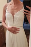 I wish this came in a size 0! Even with the adjustable lacing, the fit was so strange on my narrow & rectangular torso. I couldn't get the top lacing tight without the bottom lacing pulling the dress way down. But, I love the flowy skirt and soft chiffon.
I will be keeping it with many alterations (photos are pre-alterations):
* sew the top eyelets all the way together with elastic (I wear 30C; 29" under-bust)
* remove the lacing (27" waist; I don't need it and it looks better without)
* add some decoration to disguise the leftover eyelets
* remove a bunch of fabric around the straps
* hemming, most likely (I'm 5'6" and would need 5.5" heels)
* sew up the slit just because I don't like it--the seam will be unnoticeable given how much fabric there is
Hemming may be expensive because the skirt is a full circle with 3 layers (1 chiffon, 2 underskirts).
Comparable dresses at bridal shops go for $500 before alterations, so even with all these changes I still feel like I got a great deal! - Victoria S.