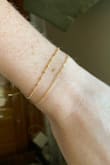 Sooo dainty. The smallest little chain. I love it, very cute. I have it on the tightest hook (3 hook options). I've worn it a few times and hasn't seemed to lose its gold/tarnish at all. - Andrea L.