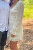 I bought this as my elopement dress and while it looked cute in pictures, I was disappointed by it for a Lulus dress and won't be rewearing it. The stitching was visibly uneven along the neckline and the hem and there were tiny brown flecks on the sleeves. It also ran large in the back although it was on the short side/this is not a dress you would want to bend over in. I LOVED the sleeves and the open back, I just wish the rest of the dress lived up to it! - Caia B.