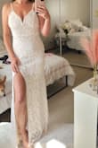 The sparkly pattern on this dress is even more beautiful and detailed in person. The straps have a nice stretch to them and there is structure in the chest area for support. It was a lot more beige than white when hung next to other white dresses. I was close to picking this for the wedding but it felt more like a prom or party dress. - Briar H.