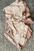 I had my eye on this for a while. I had it saved in my wish list waiting for it to go on sale because who doesn't love a sale! I finally ordered and received and I'm so disappointed with the quality. This isn't the usual Lulus quality that I've come to love and expect. I was so excited about my champagne-colored pajamas and it honestly looks like gold foil. The material is scratchy on the interior side. The stitching isn't good either as you can see in the pictures - notice the stitch line at the hem of the ruffle on the shorts. The fit is spot on for my body but I will be returning. Possibly the material looks better in one of the other colors. Good luck shopping babes! - Chelsea A.