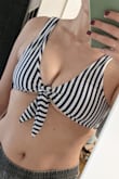 Beware if you are small with a larger cup size. Bikini tops are tricky for me because I wear a small, but for boob coverage and support need a large. I typically avoid bikini tops that don't consider in cup sizes. 

I took a risk on this since it ties. I got a size up (M) and figured I'd just tie it tighter. 

The straps are too loose for me, but the rest does not cover my nipples. If I put the band under my boobs, the top only comes 2/3 up my nipples (doing this in photo 2, wearing pasties in photo to demonstrate). The only way to cover my nipples is to tie it so tight that it flattens me out, center the front pieces of fabric, and let my boobs hang out the bottom and sides (photo 1). Not flattering.

Someday swimsuit designers will realize that not all smalls have the same chest size. - Jamie G.
