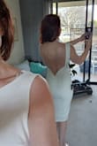 Material is thick, not see-through, and slightly stretchy. The fit is tight, but still easy to move and sit comfortably. The quality material and high-cut neckline in the front, coupled with the just-below-knee length make this dress ooze timeless class. Meanwhile the figure-hugging shape and low back make this dress an absolute bombshell. Warning, high beams can show through the material -- I'm personally going to use pasties, but more well-endowed ladies may need tape (the dress is not that supportive for the gals). Ensure you can get seam-free underwear, and be careful that any shapewear doesn't come up too high or it can be seen due to the low back. Bought this as my courthouse wedding dress, and can imagine being able to wear it out for anniversary dinners for years to come. Very Happy!! - Kate B.