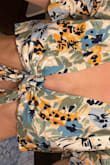 I knew I was taking a risk with all sales final but I'm shocked that it's this bad. I ordered a medium because I have a large bust and a small would be too small. I was able to tie the knot loosely so that the fabric lays across my chest vs making my boobs jump out however you can see how this gaps under so I'll need tape so that they don't come out from underneath. The fabric feels cheap, has no stretch and is even cut off center where the top shifts to the left when I move in it. Also wanted to point out the sleeves do not hit at the elbow like it shows on the model and they continually ride up so you have short puffy sleeves. Not sure why my pics are sideways but hopefully this is helpful. Do yourself a favor and skip this item. - Elise M.