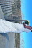 Wore it for my beach wedding and I loved it. It was a bit long but when paired with wedges it was the perfect length. Fit true to size. I have a large bust area which is usually a problem but it was perfect. More ivory with white trimming. - Gabriela B.