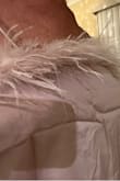 The online pictures are beautiful. Feathers are fluffy and full. That is not what you will receive. The attached boa is very thin and sparse.  The boa is very stiff which makes it lay weird in the front where it's not sewn down. Also uncomfortable when your arms rest against it. The feathers are sharp and poke you. 
I sized up after reading other reviews. It does fit my chest, but is just too boxy to be attractive. I suppose that's why all the photos show it tucked in. 
On a positive note, the color is great. it is fully lined and a nice weight fabric. I tried to show how boxy it is, but the site automatically crops the photos. You would be better off to purchase a nicer boa and attach to another top with snaps so that it can be removed for laundering. - Darla L.