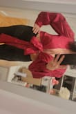 Beautiful silky red shirt. Can be tied in the front for a deeper V or crossed and tied in the back. I'm a little curvier so I liked that by tying it in the front the sides came down far enough to cover my sides which I don't love showing. Lots of cleavage of course and just a peek of front belly. Definitely give it a try! I got a ton of compliments. - Rosanne G.