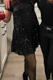 Looks exactly as pictured on model- just enough sparkle without looking too vegas-y. (If you aren't going to Vegas). I think it runs a tiny bit large because although I'm petite I have a bust and a butt/thighs but it accommodates both and was very flattering- not too tight across butt/thighs at all- has a nice swing! Also I'm only 5'0 and was happy it was short enough! - Sara L.