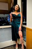I got this dress for a work holiday party themed as "casino night". I wanted something that could be both modest and sexy and this dress perfectly fits the bill. The slit doesn't move around when you walk so everything stays covered. I intentionally had to move it for this photo and it'll show some leg when sitting. But again, pretty covered up. The color is stunning in-person. I got sooo many compliments. - Salima S.