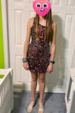We bought this dress and the teal one like it, and my daughter liked the black/multi better for her winter dance. It is a bit more red than just black, at least with our lighting. It fit her very well, and is nice and stretchy. She said the sequins are not rubbing under the arms are poking making things uncomfortable. It appears well made and looks great in person! She hasnt worn it to the dance yet, so you are let with a photo just trying on the dress for the first time, but just wanted to leave a review in case anyone is considering this beautiful dress! - Sarah S.