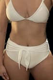 Fit snug (got a large) and has medium coverage. Holds in the belly nicely and the tie feature is cute - Jennie R.