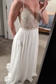 Purchased this online after reading all the reviews and seeing all the photos from other buyers. The dress arrived within a week, (I live in Canada). Very happy with the quality and fit. I had the straps taken in slightly and the dress hemmed as I will be wearing for our beach ceremony ( not wearing shoes). It was quite long with a slight train at the back. The dress is not see through as there are two layers of chiffon. The back is stunning and the built in cups worked perfectly, no bra needed. As others mentioned, the side white ribbon (used to hang the dress) is sewed right into the fabric. This is a huge issue as it is sheer on the sides and if you cut the ribbon back there is still a small portion showing. I had the seamstress fix this and restitch the sides. Other then that it is a great dress. - Sarah R.