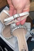 There is nothing there to hold the extra ankle strap down, which is really annoying. It's too bad because I absolutely love the shoes, however, my matron of honor said, we can tie them down with a white thread and it won't show. She was right, so I'm keeping them. But still, how inconvenient and big design flaw, 3 stars because I think they're gorgeous, 2 off for inconvenience and design flaw. - Catherine B.