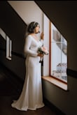 I wore this dress to my small wedding in January. It is thick so it kept me warm. Great quality, I just had to get the sleeves and bottom hemmed. I am 5'5" and 128 pounds. I wore a sticky bra from Amazon and shapewear from honeylove. If you are thinking about getting this dress, get it! - Nicole W.