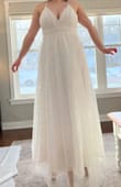 I was suuuper excited to try on this dress. It's gorgeous! And the skirt definitely was (look at how the light shines through it!!!)! But the bodice looks absolutely nothing like it does in the photo. First, the neckline doesn't have the defined swoop into the V like you can see on the model. The actual dress had a lot of loose tulle fabric, making the swoop and V messy-looking and less elegant. Second, the model-image looks like there is more structure and shape in the bodice, but there is neither, making it a bit unflattering for bigger chests. The shape looks more like the sundresses I wore in middle school :( I really wish it were not the case, since I LOVED the skirt so much. Also, it is very long, which was expected! - Christiane L.