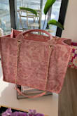 Strong canvas with a bottom liner too and some pockets on the side inside as well. The chain looks and feels expensive. Sooooo many compliments. - Megan F.
