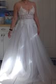 When first looking for dresses, I passed this one up cuz it looks so sheer in the photo. But after reading reviews, I went for it. It truly isn't as see-through as it is in the model picture. Love the dress, the straps are the only downside. I will have to have it altered with actual straps. The tulle thin ones it comes with are mostly just for show. They don't stay on my shoulders at all and don't hold up the dress. 

The fit is great, based on reviews I ordered a 6. Zips up great. In other Lulus dresses, I range from 4-6. In the bridal salon, I was a 6-8. For reference, I have broad shoulders. 

Definitely excited to wear this on the big day, wish it had a train, but can always just add with altercations. - Lisa L.