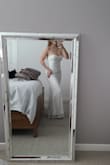 It's a really pretty dress. I ordered the M, I'd usually get a S, but I'm happy I didn't. The top is nice, although it might be too much cleavage for me (43) at my small wedding. That's not the dresse's fault. It is a bit sheer, if I decide to wear it on my day, I'll need to add a slip, I can see about 30% of my light colored thong through the back.
It's a nice dress, probably meant for a smaller chested woman. It will need 2"or higher heels,or a hem job.
:) - Lesley W.