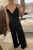 Cowl neck AND back, strappy open back, jumpsuit with leg slits, luxurious silky black fabric... what more could you want?! (*ahem! pockets!*)

Unfortunately, the fit was pretty bad on me. The cowl neck was too low-cut, so instead of giving a flattering illusion like most cowls do, there was no hiding my lack of cleavage...especially if I leaned forward to any degree, giving a clear view of my ENTIRE torso down to my navel. No amount of double sided sticky tape was going to cut it. 

The sliding straps cut in to my shoulders a bit while somehow still feeling unsecured. The fit through the waist/hips was funny, gave my butt a whole new shape that I wasn't loving. And, as you can see in the first photo, the legs would have needed to be hemmed even with 3" heels. Darn :( - Alexandra H.