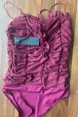 This top is listed under the red color when I filter in tops and the photos give the customer the sense that this top is a dark red color. The top is actually a maroon/purple color which was not what I was looking for. Although the shipping was really quick and the size was quite alright. - Caitlin Q.