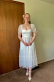 I love this dress! I'm planning on wearing it to my bridal shower! The fabric is very comfortable and has a little stretch, and the bodice has a light boning along the sides that I don't think I noticed in other Lulu dresses which adds a very flattering shape. Bonus, it has POCKETS! 
My measurements always match to the lower end of the medium size on the size chart, but I prefer wearing size small in Lulus dresses for a slimmer fit so I am glad that I sized down to a small. The only part that doesn't fit perfectly is the bustier cups but I know I have a larger chest and sized down intentionally. Overall it is a beautiful and quality dress! - Sydney E.