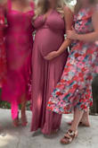 I purchased this dress (size: L) for a wedding. I would normally go for a medium, but I am almost six months pregnant so I sized up. It fit perfectly. I am 5'4'' and a half, and wore flats, and the dress just barely brushed the floor. It was soft and comfortable. It made the bump look super cute. The fabric is also really nice, almost exactly as pictured. I also loved all the different ways you can style it. I would recommend this dress for anyone. I'm pretty sure I'd still be able to wear it even if not pregnant, which is also why I bought. - Mikayla M.