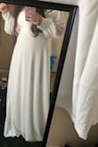 I have been nonstop searching for my wedding dress. I found this one and it was finally in stock, ordered and prayed it would look just like the photo and my prayers were answered. It's long and flowy, the button detailing on the sleeve cuffs is beautiful and overall fits snuggly and hugs all the right curves. The fabric itself is nice but a little see-through, so I'll probably wear something white underneath. I do wish the sleeves were a little longer so I can wear the sleeves on my shoulders instead of the off-the-shoulder look but overall I am so happy with it! - Maria G.