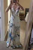 This is such a pretty, feminine dress. It has a romantic vibe. I bought the white/cream with floral version to potentially wear for my wedding related events but it's got enough color to not look super bridal to wear on a date or something. Definitely too white based to wear as a wedding guest imo.
I have a petite chest so you can see in the photo I'll really have to hike the straps up but it does fit when I do that and I still feel contained when properly adjusted. Love the low back. The belt needs to be tied pretty snug to look put together or it looks droopy. It's VERY long. Even at 5'4" in 3" heels I will definitely need to get it hemmed but love the flow with the slit. - Jenna L.