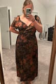 It looks just like the photo but it is slightly loose up around the sleeves and bust area. I'm usually a size 14 and ordered the XL. And it says midi but it nearly touches my ankles (I'm 5'6). I plan to get it tailored because I think it can be easily fixed. It's a really pretty fabric and I think it's perfect for a fall wedding. Note: in the photos, I'm pulling it back to fit better around my torso. - Christen K.