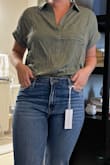 I love this top. I got it in olive green and it looks just as pictured. I am usually a medium or large and chose the medium based on other comments, it fits perfectly. The material is very soft and comfortable. When it arrived, it was super wrinkly and did get some creases throughout the day, but it dried straight without needing any ironing. It's a little bit longer, especially in the back, so I think it looks best tucked in. It's a great top! - Abbey M.