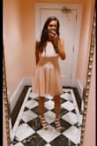 I was in need of a summer semi-formal re-do and this dress fit the bill. The color comes across as more ballet pink than peach, but I think it works well for day or nighttime events. It is double lined so no need to worry about slip-ups and I didn't need a bra here but appropriate undergarments help as it does fit up top more like a strapless dress. The V-neck is pretty and dresses up the overall look while the waistbelt keeps it classy. Would highly recommend it for mixers and the like. Just be careful as the fabric is prone to snag or stain. - Simone B.