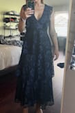 I ordered this for a black tie optional wedding and I love the way it looks. I sized down because I feel Lulus items usually run large on me. I'm usually a small but ordered an XS. It fits perfectly. I have an athletic type body. The deep v cut worried me but it doesn't show anything at all when I move around. It's so flattering and sexy all while still being conservative for a wedding. I joked I felt like a Victorian-era ghost, though (lol). The only negative I could say is that when you move around the layers move with you, and you can see the underside of the dress which is a different material than the lace on top. But not a huge deal. Only if you're dancing crazy. Beautiful dress!!! - Amanda N.