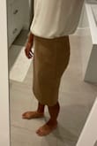 This skirt is cute, but I did order a size up from my normal size. The xs was just a little tight at the waist. The material is a little thin. When you tuck things in, you can see bumps and bulges, but overall it works for work. I don't love the length for me, but I could always get it hemmed if I wanted to put in the effort. - Caroline M.