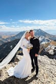 Strapped this baby to the outside of my pack and hicked it up a mountain for my private wedding ceremony and it did not disappoint. I'm 5'4", 140lbs, and the dress fit like a glove except for in the chest. It wasn't gaping by any means but it did feel slightly looser than the rest of the fit so I imagine it could definitely accommodate bigger busts. The fabric is on the heavier side and STRETCHY! It feels so nice! It does have a liner and I was worried I would have to pull it down constantly so it wouldn't crinkle and show in photos but I actually didn't have any issues with that. I love the wide neckline and plunging back and the buttons trailing down the back add such a beautiful touch! The dress was very long on me but given our situation, I wasn't going to be walking around in it so I didn't bother to have it tailored. Very happy with how it turned out, especially with such a reasonable price tag! You can't beat that! So gorgeous!!! The white opalescent flower earrings were from Lulus too! - Vada C.