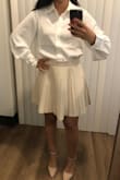 This is not your basic button-up white shirt. It has large and kind of flowy, long sleeves. I love wearing it under sleeveless dresses and tops. It elevates the look in a few seconds. The only downside is that the fabric wrinkles easily. - Ester F.