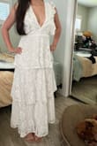 I ordered the dress in both small and medium. The medium ended up fitting me better. It was still a bit loose under my arms, but it fit better around my waist than the small one, as I wanted it to be looser and not feel too tight when I was moving around or sitting down. I already knew from reading other reviews that the dress would have a very low cut, so I had a seamstress add an organza layer and cut the ruffle parts a bit to look more delicate. I just didn't expect it to be so long, but at least it didn't touch the floor. Overall, it was perfect for my civil ceremony! - Stefane H.