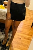 I'm absolutely thrilled with this short black skirt featuring a stylish slit! The design adds a hint of allure while maintaining a sophisticated look. The quality of the fabric is impressive, offering both comfort and a flattering fit. It's versatile enough to dress up for a night out or pair with a casual top for a chic daytime look. This skirt has quickly become a staple in my wardrobe, and I can't get enough of its trendy yet timeless appeal. A definite must-have for any fashion-forward individual! - Anastasia D.