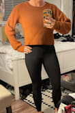 The sweater actually has a really cute fit. I love the thumb holes in the sleeves as well. The only thing is that I have not washed it yet, and I am afraid to, based on another sweater I purchased from Lulus. Washing my other sweater, I ruined it so now I'm scared to wash this one. If it maintains its size and shape, though, it is super cute. I highly recommend it. It is borderline too short. Again, as long as it maintains its size and fit under the armpits after washing, I'm sold. Also, it is definitely more brown than rust orange, even though the lighting in my photo doesn't really show that. - Andrea B.